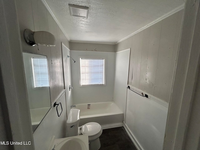 bathroom with shower / bathing tub combination, a textured ceiling, toilet, wood walls, and crown molding