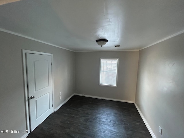 spare room with ornamental molding and dark hardwood / wood-style floors