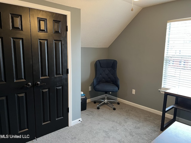 carpeted home office featuring lofted ceiling