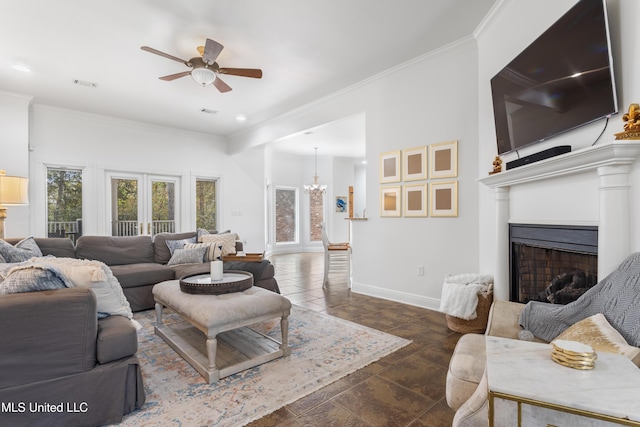 living room with french doors, ceiling fan with notable chandelier, and ornamental molding