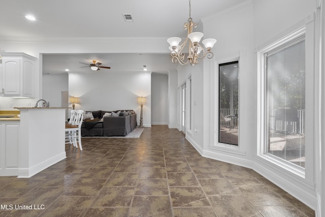 dining space featuring ceiling fan with notable chandelier and crown molding