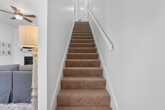 staircase featuring ceiling fan and ornamental molding