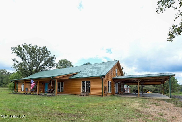 back of property with a carport and a lawn