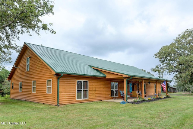 rear view of property with a yard and a patio area