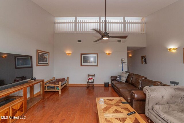 11088 Tahiti St, Bay Saint Louis, MS 39520 - living room with a ceiling fan, wood finished floors, a high ceiling, and baseboards