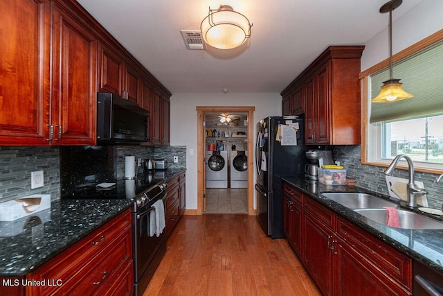 11088 Tahiti St, Bay Saint Louis, MS 39520 - kitchen featuring appliances with stainless steel finishes, separate washer and dryer, a sink, backsplash, and light wood-style floors