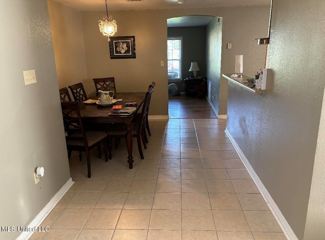 dining area featuring a notable chandelier and light tile patterned floors