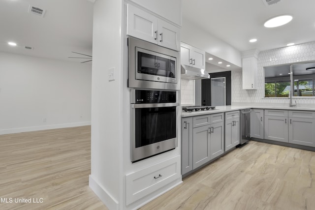 175 Saint Charles Ave, Biloxi, MS 39530 - kitchen featuring stainless steel appliances, gray cabinetry, light countertops, light wood-type flooring, and recessed lighting