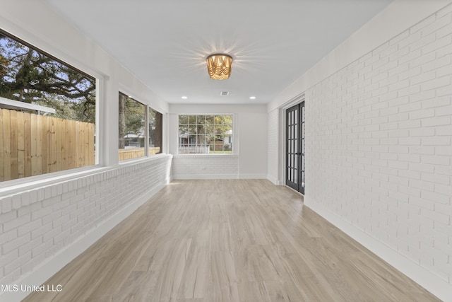 175 Saint Charles Ave, Biloxi, MS 39530 - unfurnished sunroom featuring brick wall, wood finished floors, and french doors