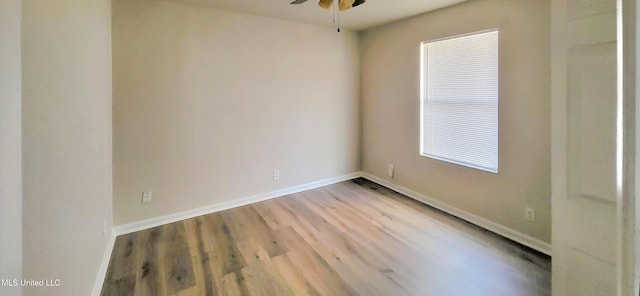 empty room with ceiling fan, baseboards, and wood finished floors