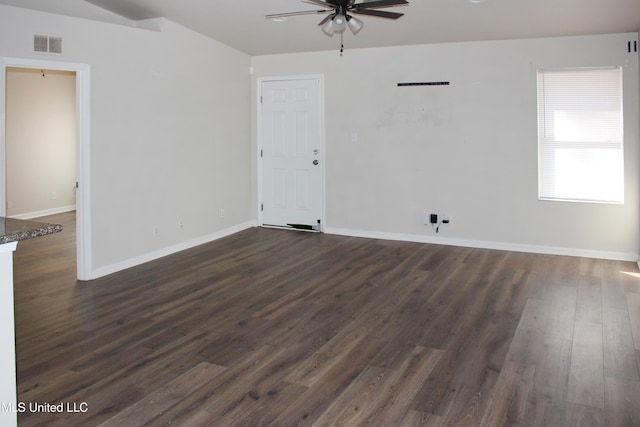 spare room with a ceiling fan, dark wood-type flooring, baseboards, and visible vents