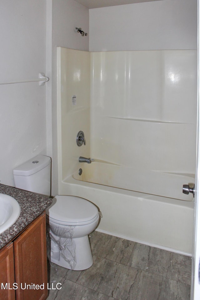 bathroom with vanity, shower / tub combination, and toilet