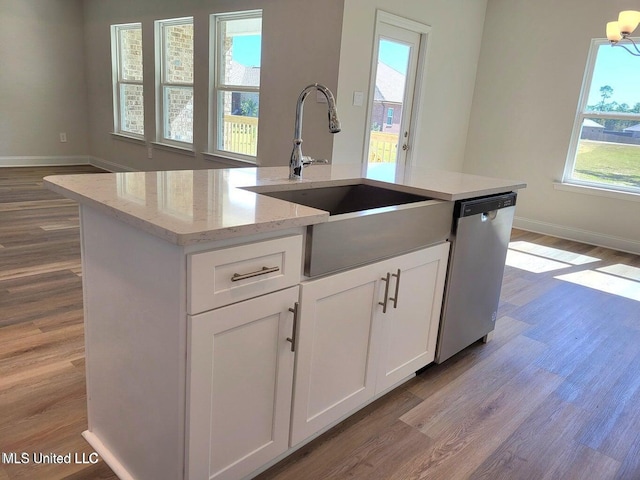 kitchen with sink, white cabinets, a kitchen island with sink, stainless steel dishwasher, and light stone counters