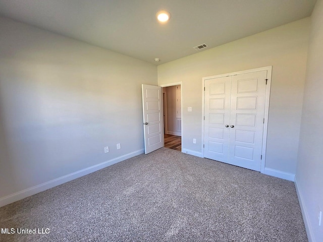 unfurnished bedroom featuring carpet and a closet