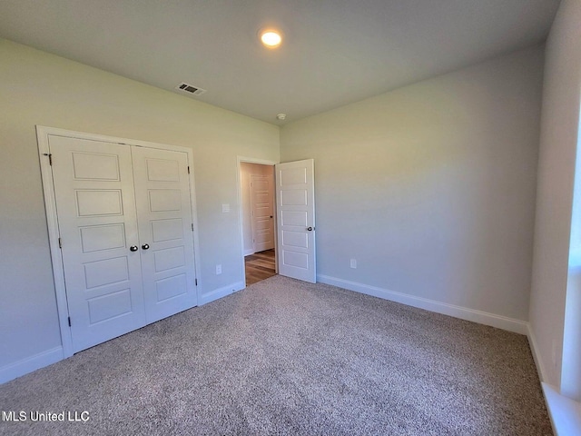 unfurnished bedroom featuring carpet and a closet