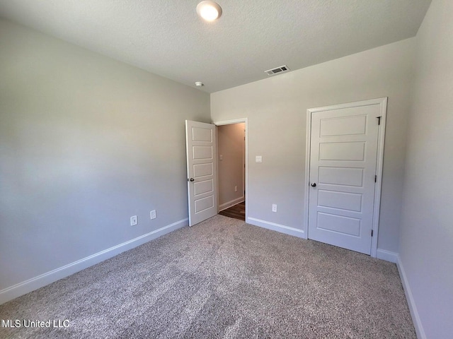 unfurnished bedroom featuring a textured ceiling and carpet flooring