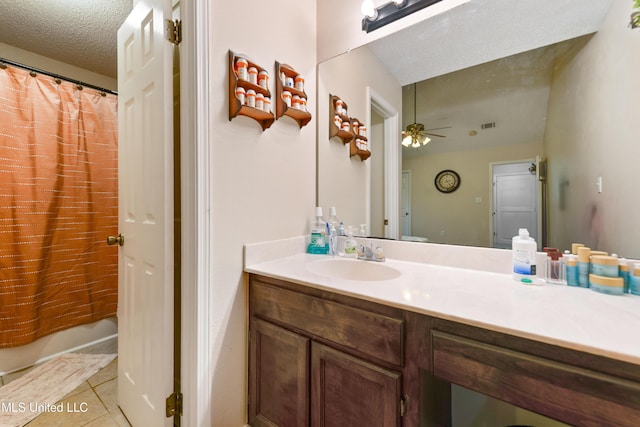 14174 Spruce Ct, Gulfport, MS 39503 - full bathroom with vanity, tile patterned floors, a ceiling fan, a textured ceiling, and a shower with curtain