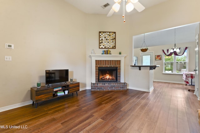 14174 Spruce Ct, Gulfport, MS 39503 - living room with wood finished floors, a chandelier, a ceiling fan, a fireplace, and baseboards