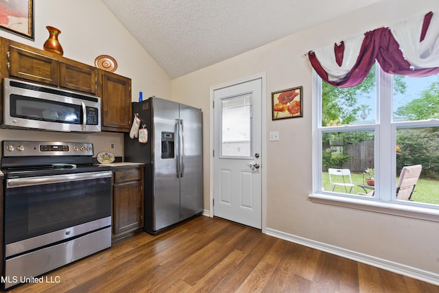 14174 Spruce Ct, Gulfport, MS 39503 - kitchen with appliances with stainless steel finishes, vaulted ceiling, dark wood-type flooring, a textured ceiling, and baseboards