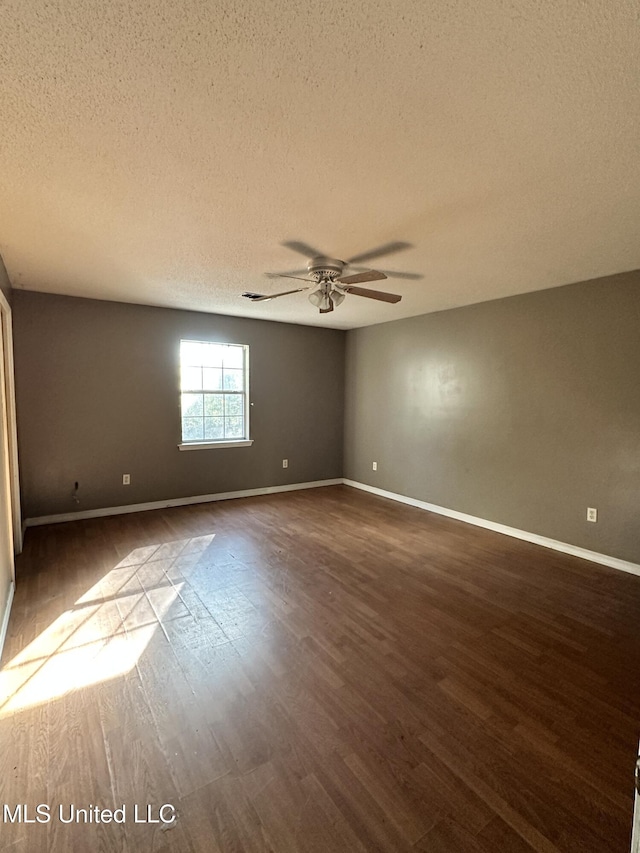 spare room with a textured ceiling, dark hardwood / wood-style floors, and ceiling fan