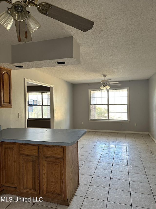 kitchen featuring a wealth of natural light, light tile patterned floors, a textured ceiling, and ceiling fan