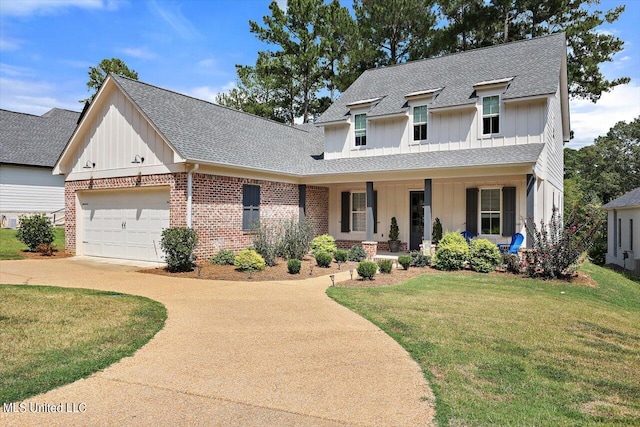 view of front of property with a front yard, covered porch, and a garage