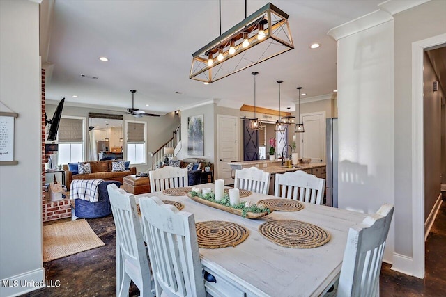 dining area featuring crown molding, sink, and ceiling fan