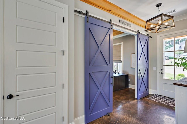 entryway featuring ornamental molding, an inviting chandelier, and a barn door