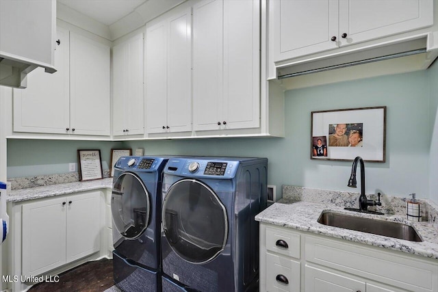 laundry area featuring cabinets, sink, and washer and clothes dryer