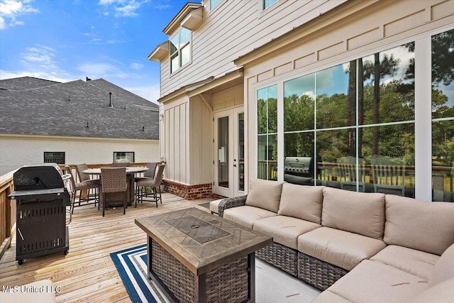 wooden terrace with area for grilling, french doors, and outdoor lounge area