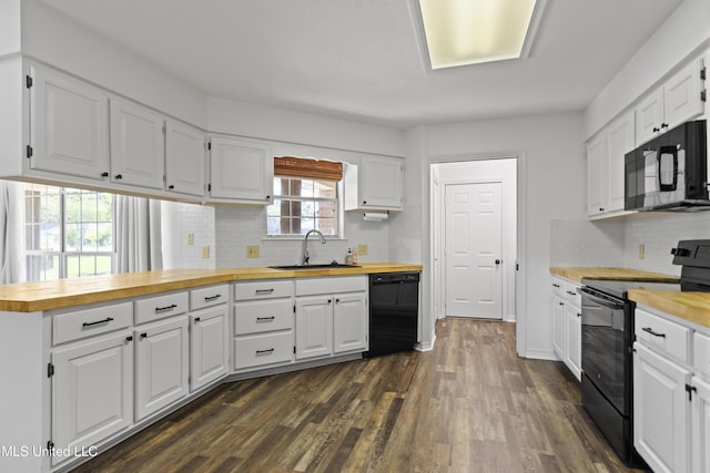 kitchen featuring white cabinets, dark wood-style flooring, a sink, butcher block counters, and black appliances