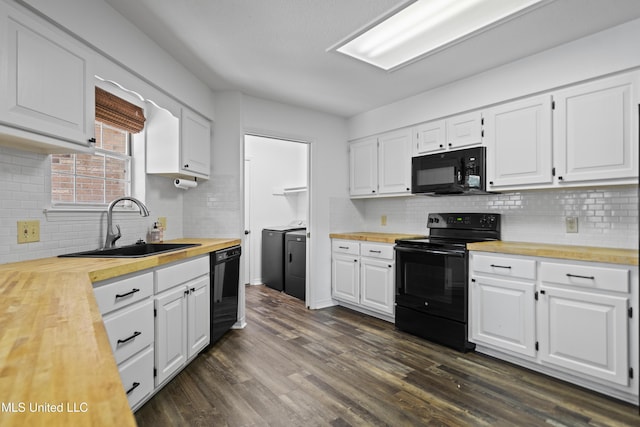kitchen with a sink, wood counters, black appliances, and independent washer and dryer