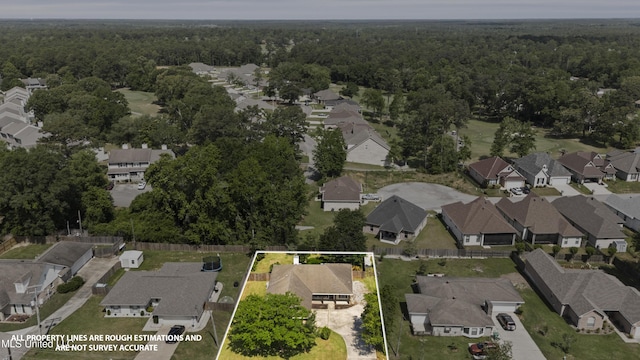 drone / aerial view featuring a forest view and a residential view