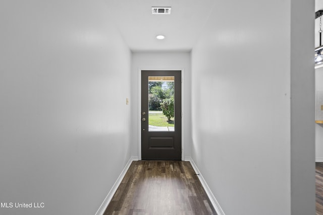 doorway featuring baseboards, dark wood-style floors, and visible vents