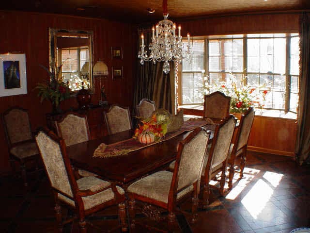 dining space featuring a wealth of natural light, wood walls, and an inviting chandelier