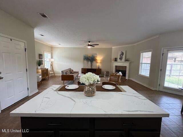 935 Frisky Dr, Brandon, MS 39047 - living room featuring ceiling fan, a fireplace, crown molding, baseboards, and tile patterned flooring
