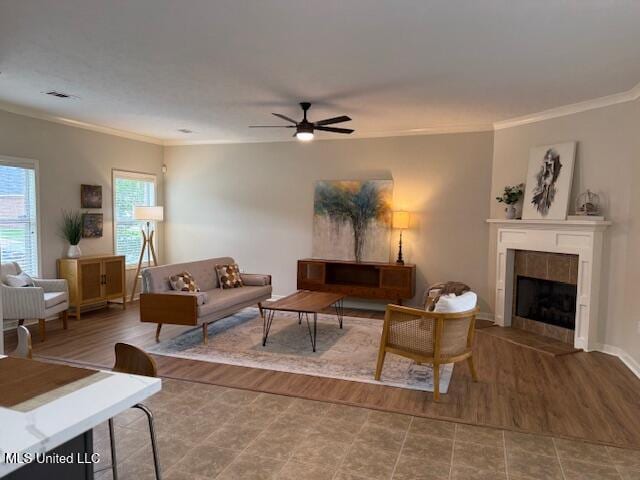 935 Frisky Dr, Brandon, MS 39047 - living room featuring crown molding, a ceiling fan, a tile fireplace, wood finished floors, and baseboards