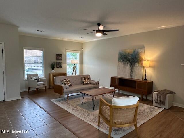 935 Frisky Dr, Brandon, MS 39047 - living area featuring a ceiling fan, baseboards, tile patterned floors, and ornamental molding