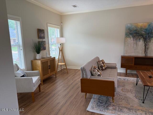 935 Frisky Dr, Brandon, MS 39047 - living room featuring wood finished floors, plenty of natural light, and crown molding