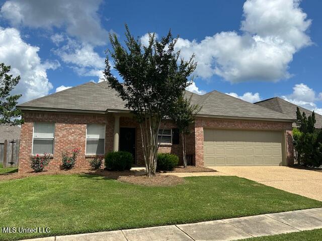 935 Frisky Dr, Brandon, MS 39047 - view of front of property featuring an attached garage, a front lawn, concrete driveway, and brick siding