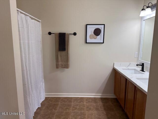 935 Frisky Dr, Brandon, MS 39047 - bathroom featuring double vanity, baseboards, tile patterned floors, and a shower with shower curtain
