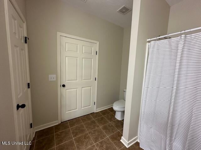 935 Frisky Dr, Brandon, MS 39047 - full bath featuring toilet, tile patterned flooring, baseboards, and a shower with curtain