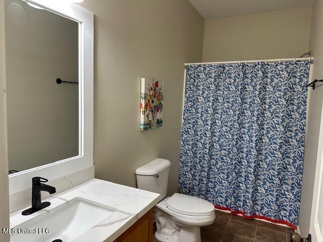 935 Frisky Dr, Brandon, MS 39047 - full bath with vanity, toilet, tile patterned floors, and a shower with curtain