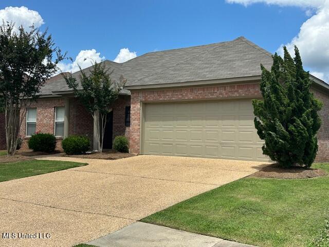 935 Frisky Dr, Brandon, MS 39047 - view of front of home featuring driveway, a garage, and brick siding