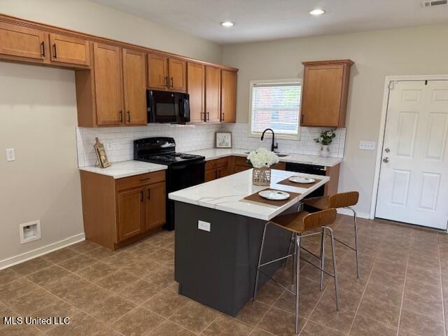 935 Frisky Dr, Brandon, MS 39047 - kitchen with black appliances, brown cabinets, backsplash, light countertops, and recessed lighting