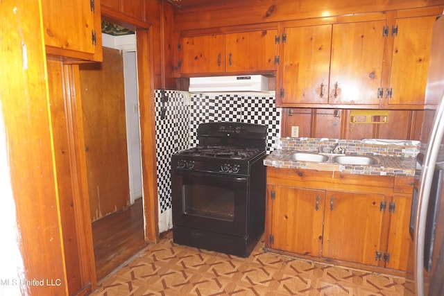 3828 California Ave, Jackson, MS 39213 - kitchen featuring black range with gas cooktop, custom exhaust hood, a sink, and brown cabinetry