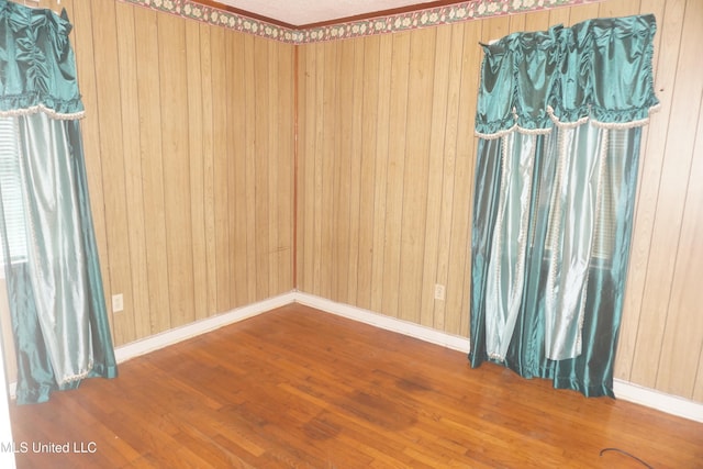 3828 California Ave, Jackson, MS 39213 - spare room featuring wood finished floors, wood walls, and baseboards
