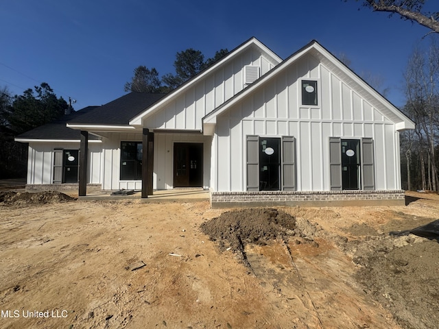 modern inspired farmhouse featuring a shingled roof and board and batten siding