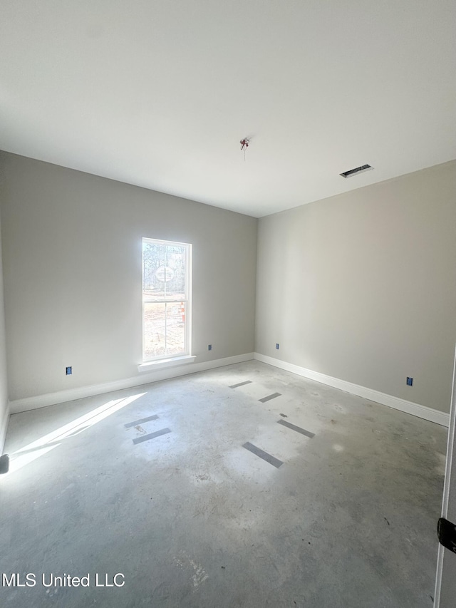 spare room with baseboards, unfinished concrete floors, and visible vents