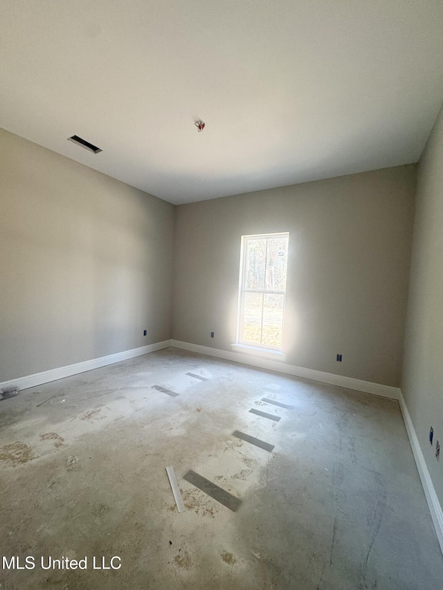 unfurnished room with baseboards and visible vents